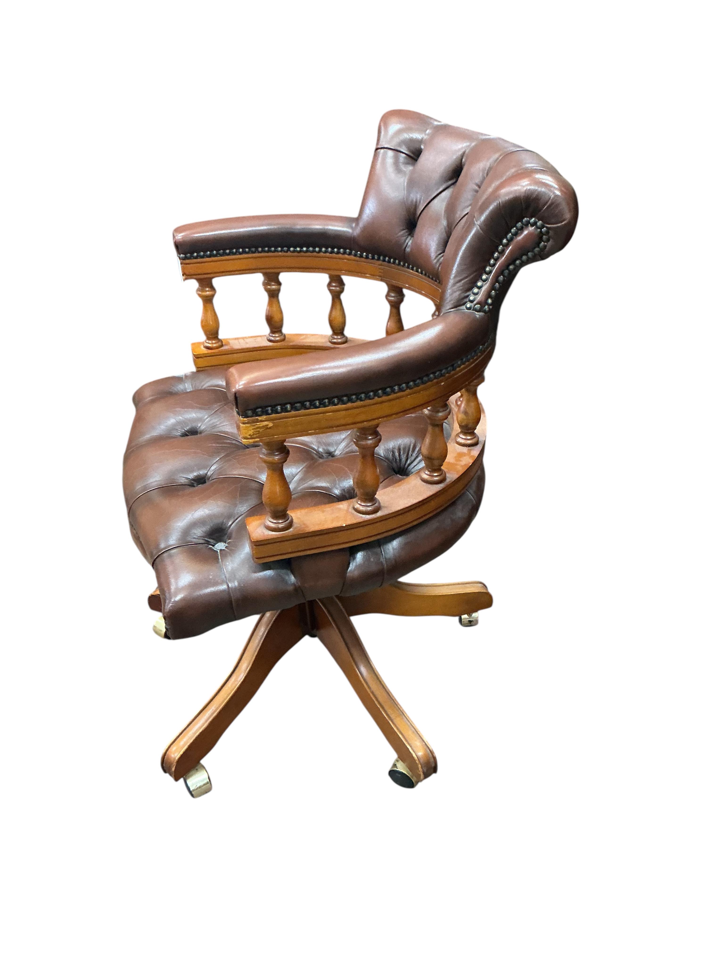 A reproduction mahogany and buttoned brown leather swivel desk chair, width 61cm, height 88cm
